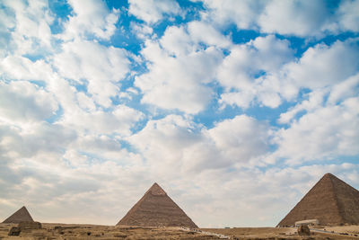 Low angle view of historical building against cloudy sky,  pyramids 