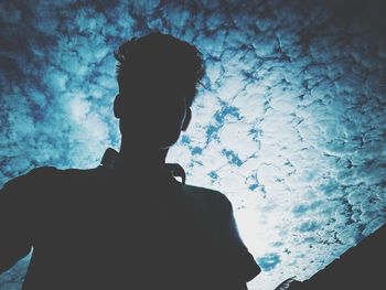 Rear view of silhouette man standing against wall