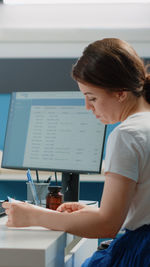 Side view of young woman working at office