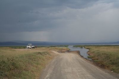 Car on road by sea against sky