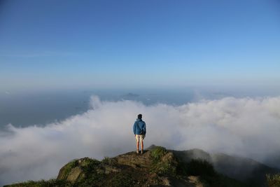 Rear view of man on mountain against sky