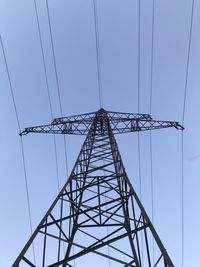 Low angle view of electricity pylon against clear sky