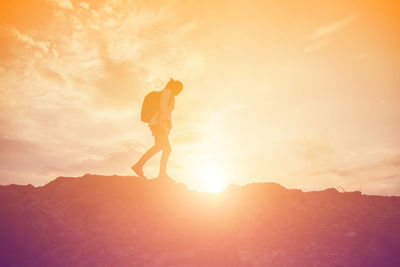 Silhouette man standing on mountain against sky during sunset