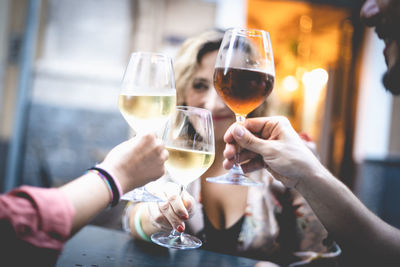 Midsection of woman holding wine glass