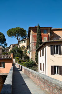 Elevated walkway in perugia against clear blue sky