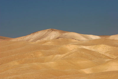 View of desert against clear blue sky