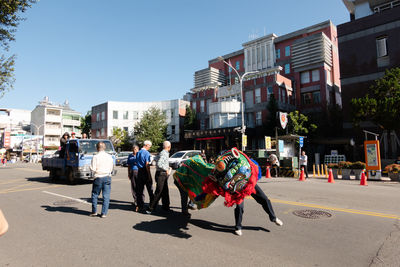 Group of people on road against buildings