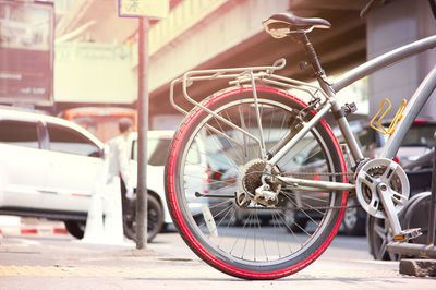 Close up bicycle at parking space with background traffic steet in the city 