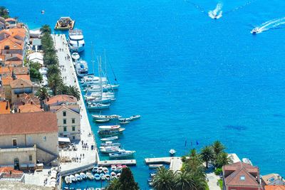 High angle view of town by sea against blue sky