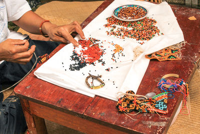 A woman made toraja typical accessories in front of a souvenir shop