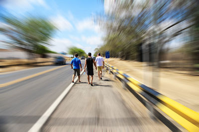 Blurred motion of men walking on road