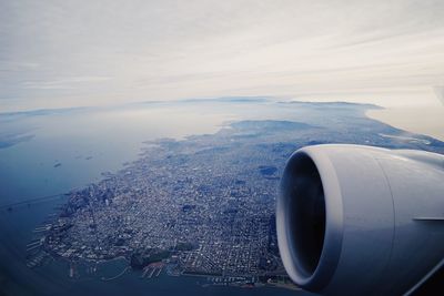 Close-up of airplane flying over sea against sky