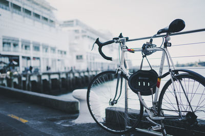 Bicycle parked against sky in city