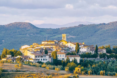 Houses in town against cloudy sky