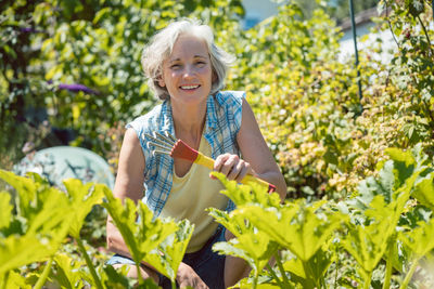 Portrait of a smiling young woman holding food outdoors