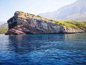 Scenic view of rock formation in sea against sky