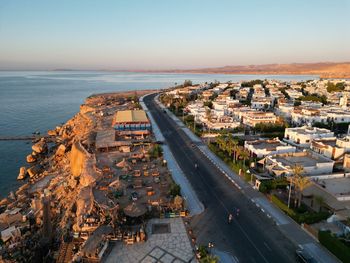 High angle view of city by sea against clear sky