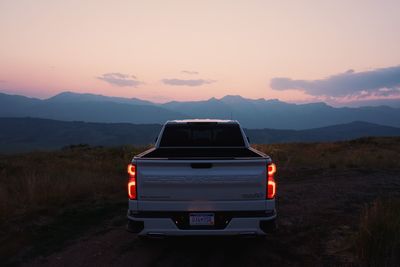 Car on field against sky during sunset