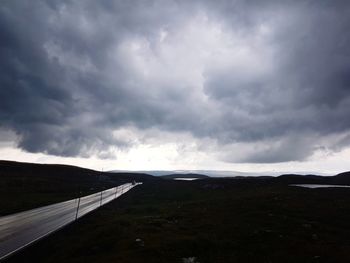 Road leading towards mountain against sky