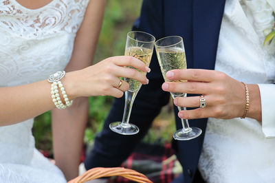 Midsection of wedding couple toasting champagne