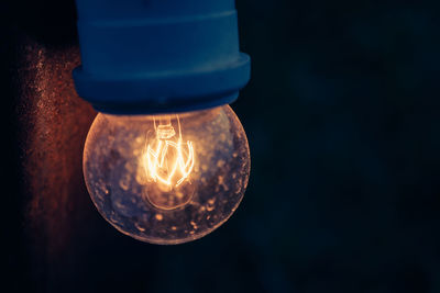 Close-up of light bulb hanging outdoors