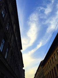 Low angle view of buildings against cloudy sky