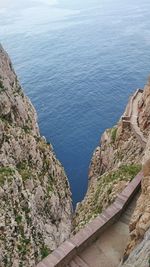 High angle view of sea by mountain against sky