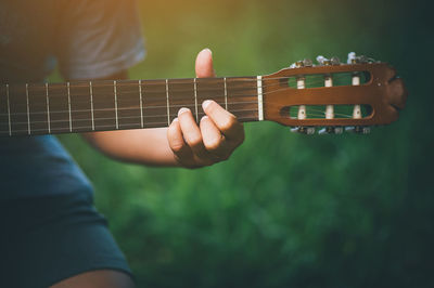 Midsection of person playing guitar