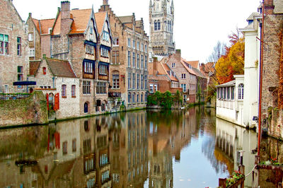 Canal amidst buildings in city against sky