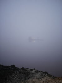 Scenic view of sea against clear sky during foggy weather