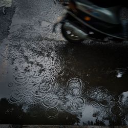 High angle view of motor scooter on road during rainy season