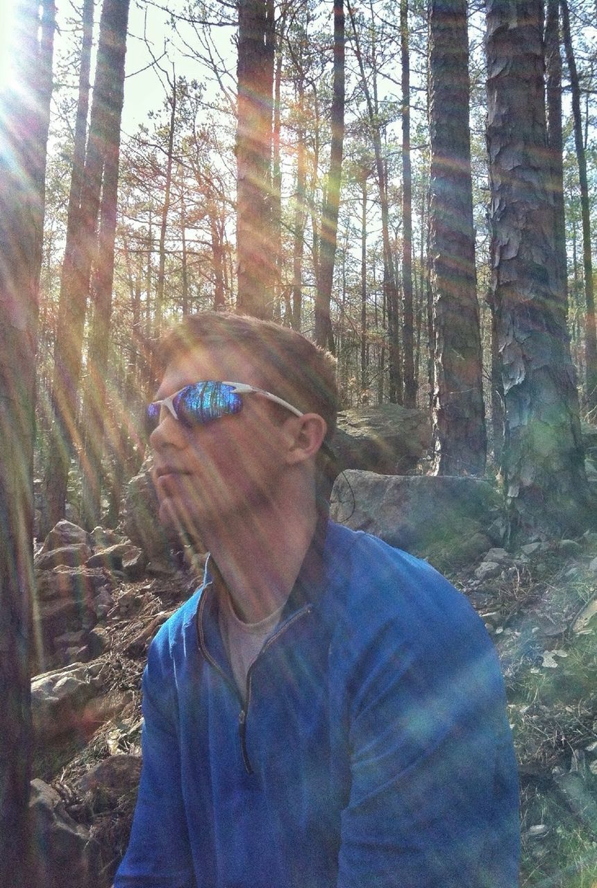 tree, lifestyles, young adult, leisure activity, headshot, casual clothing, young men, person, portrait, looking at camera, forest, front view, tree trunk, mid adult, sunlight, sunglasses, men, day