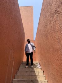 Rear view of man standing on staircase