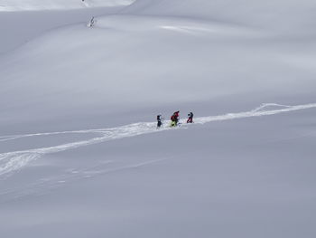 High angle view of people skiing downhill on snow