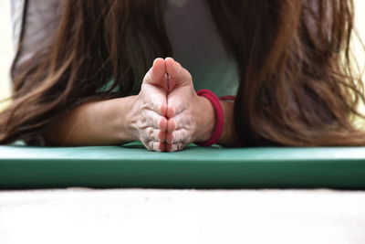 Woman meditating on exercise mat at home