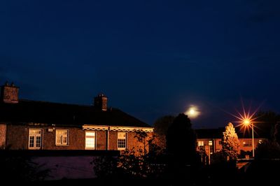 Illuminated buildings against sky at night