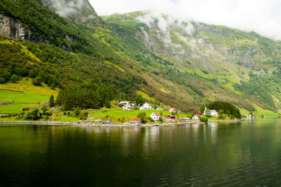 Scenic view of lake by mountain against trees