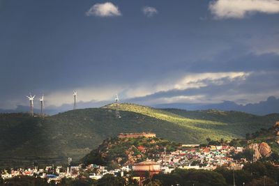 Panoramic view of townscape and mountains against sky