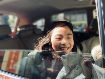 Portrait of young woman little girl sitting in car