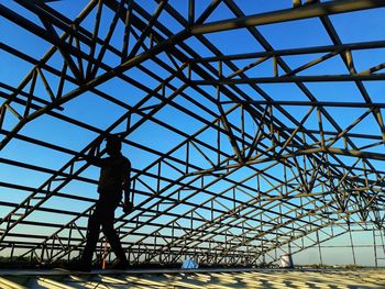 Man standing below metallic roof