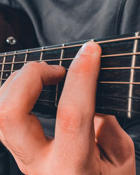 Midsection of man playing guitar