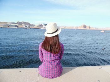 Rear view of woman standing in front of sea