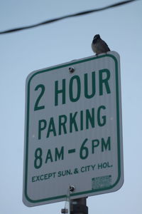 Low angle view of information sign against clear sky