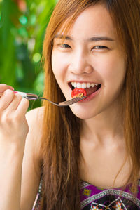 Close-up portrait of a beautiful young woman eating