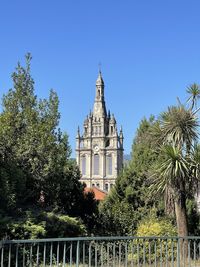 Trees and buildings against clear sky