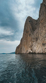 Rock formations by sea against sky