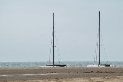 Sailboat on beach against clear sky