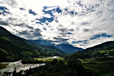 Scenic view of mountain range against cloudy sky