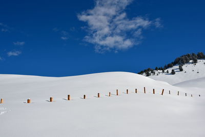 Scenic view of snowcapped mountains against blue sky