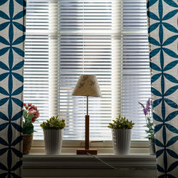 A window with blue curtains, beautiful light comes in through the blinds